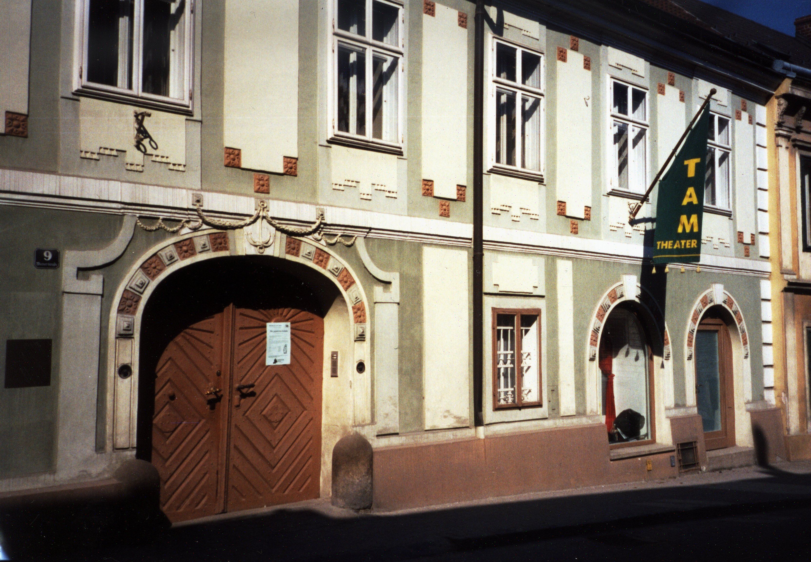 Fassade des TAM - Theater an der Mauer mit Eingangstür und Fenstern.