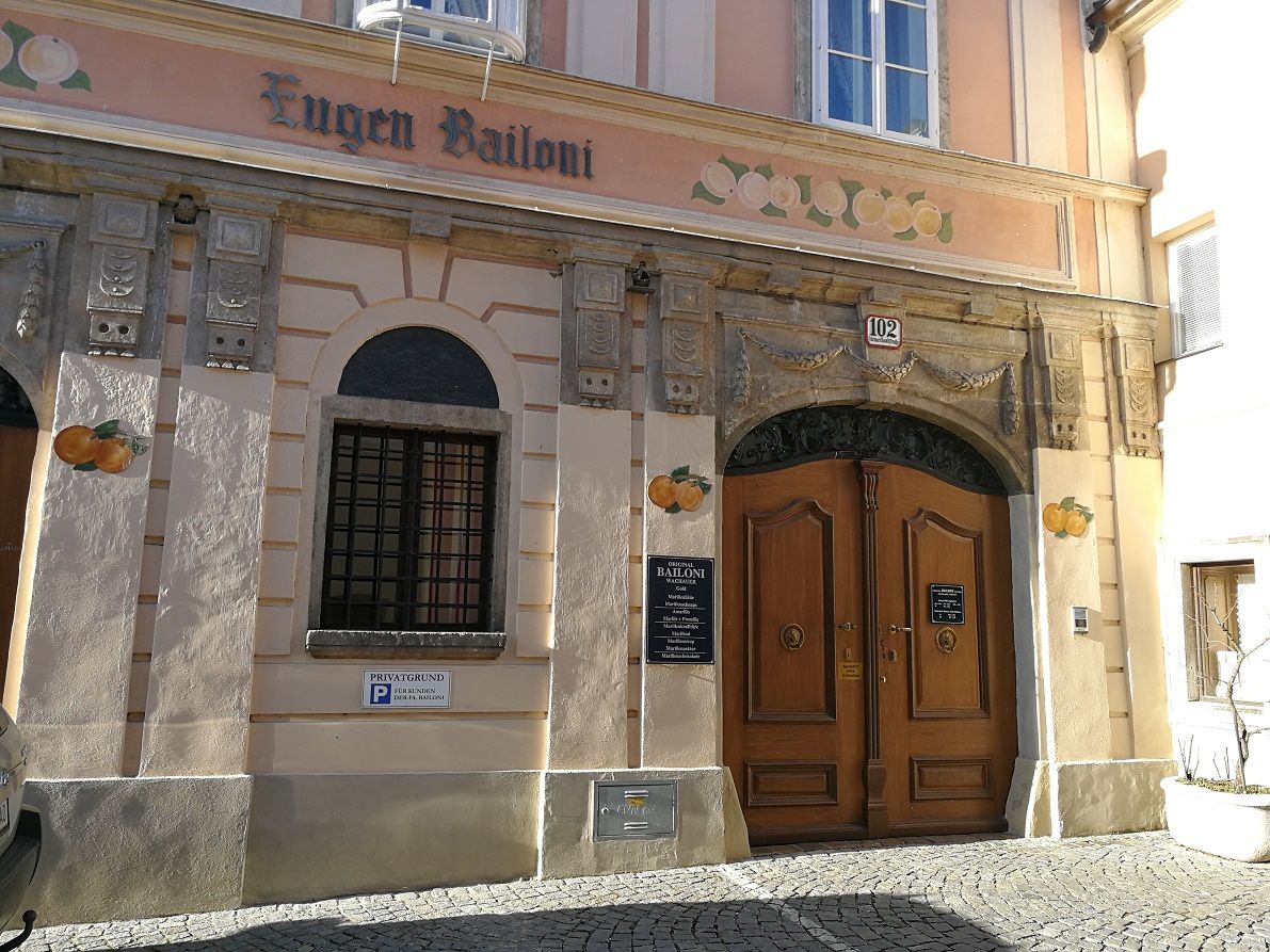 Historische Fassade mit Holztür und Schriftzug 'Eugen Bailoni'.
