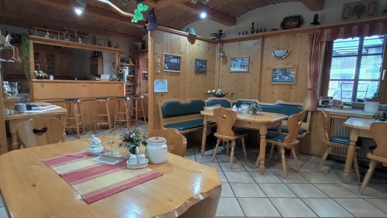 Gem&uuml;tlicher Fr&uuml;hst&uuml;cksraum mit Holzm&ouml;beln und Dekorationen.