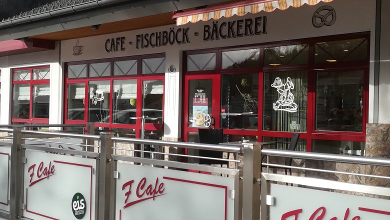 Außenansicht eines Cafés mit rotem Rahmen und Beschriftung 'Café Fischböck Bäckerei'.