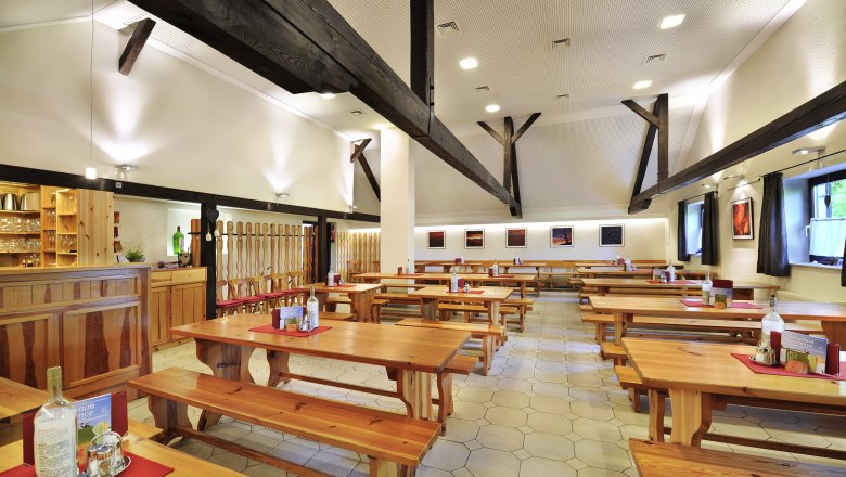 Innenansicht eines Weinguts mit Holztischen und B&auml;nken.