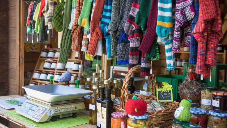 Marktstand mit gestrickten Socken, &Ouml;lflaschen und Einmachgl&auml;sern.