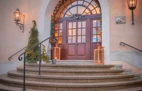 Eingang mit dekorierten Weihnachtsb&auml;umen und Lichtern.