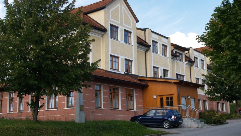 G&auml;stehaus der HLUW-Yspertal mit geparktem Auto und B&auml;umen.