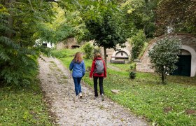Zwei Frauen auf einem Wanderweg durch ein Kellerviertel.