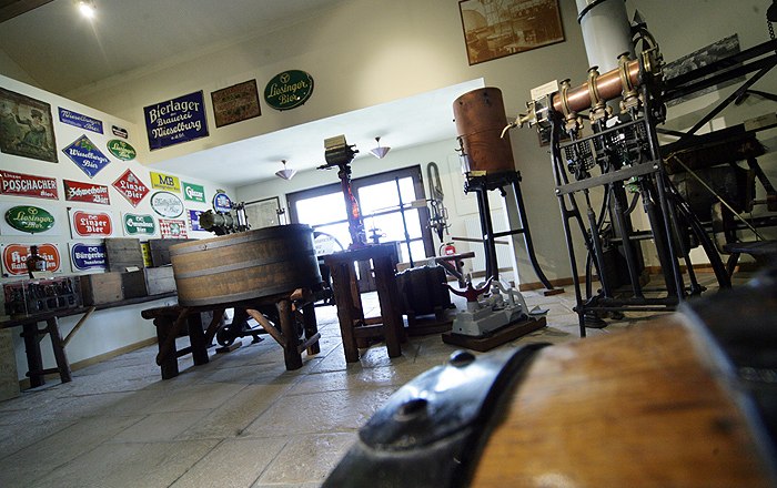 Innenansicht des Brauereimuseums Wieselburg mit alten Brauereigeräten und Schildern.