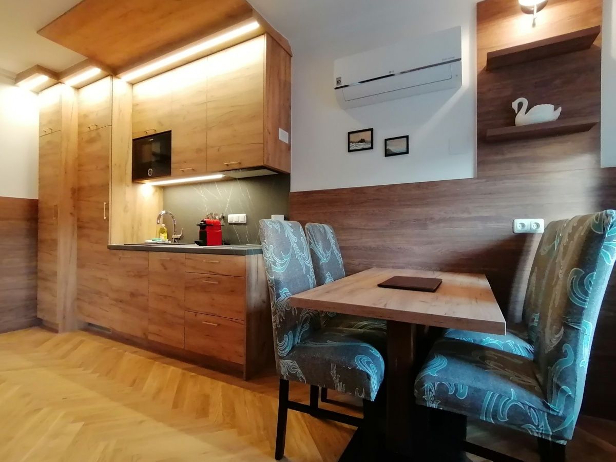 Moderne Küche mit Holzmöbeln und Esstisch in einem Apartment.