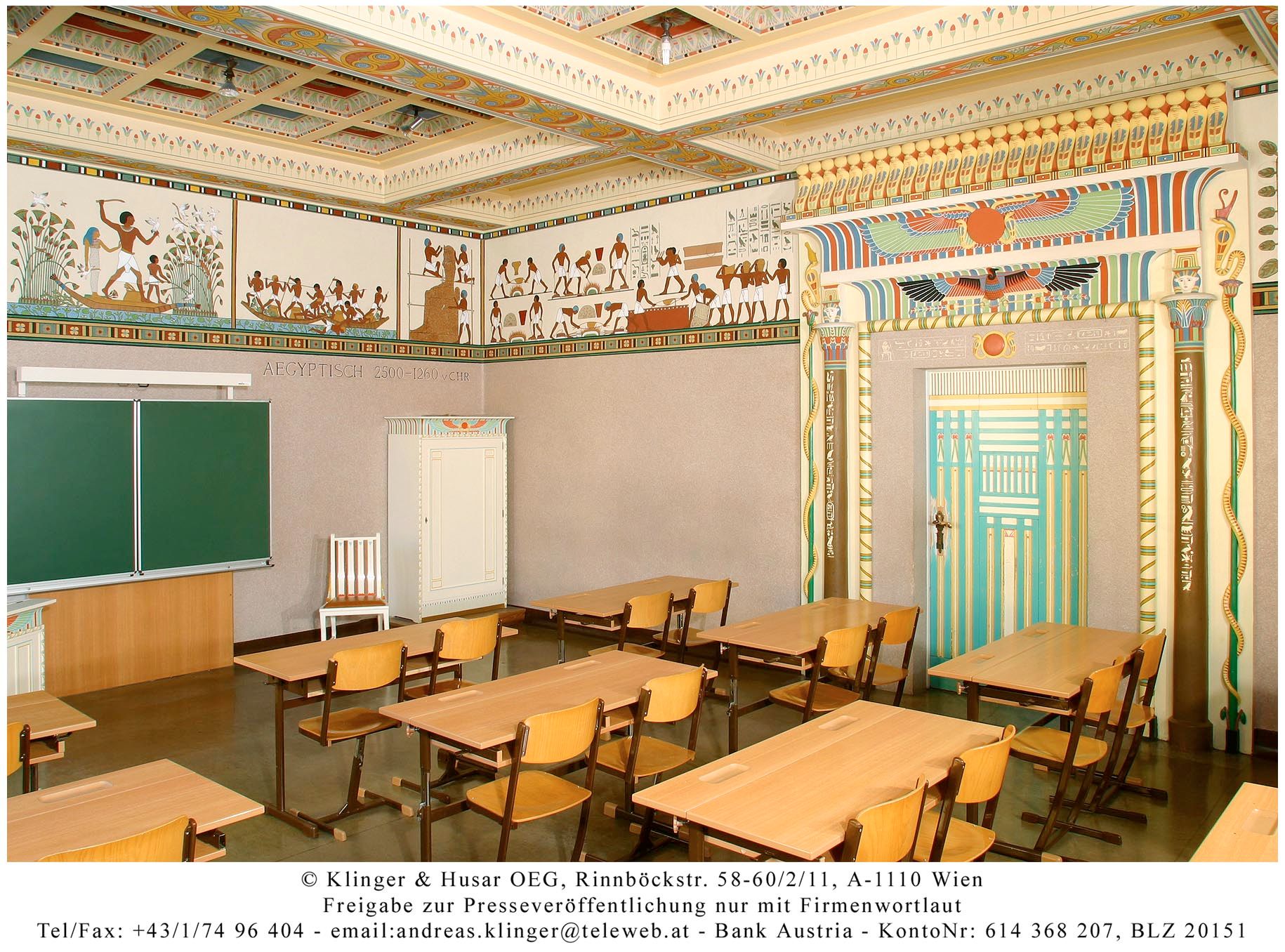 Klassenzimmer im ägyptischen Stil mit Wandmalereien und dekorativem Türrahmen.