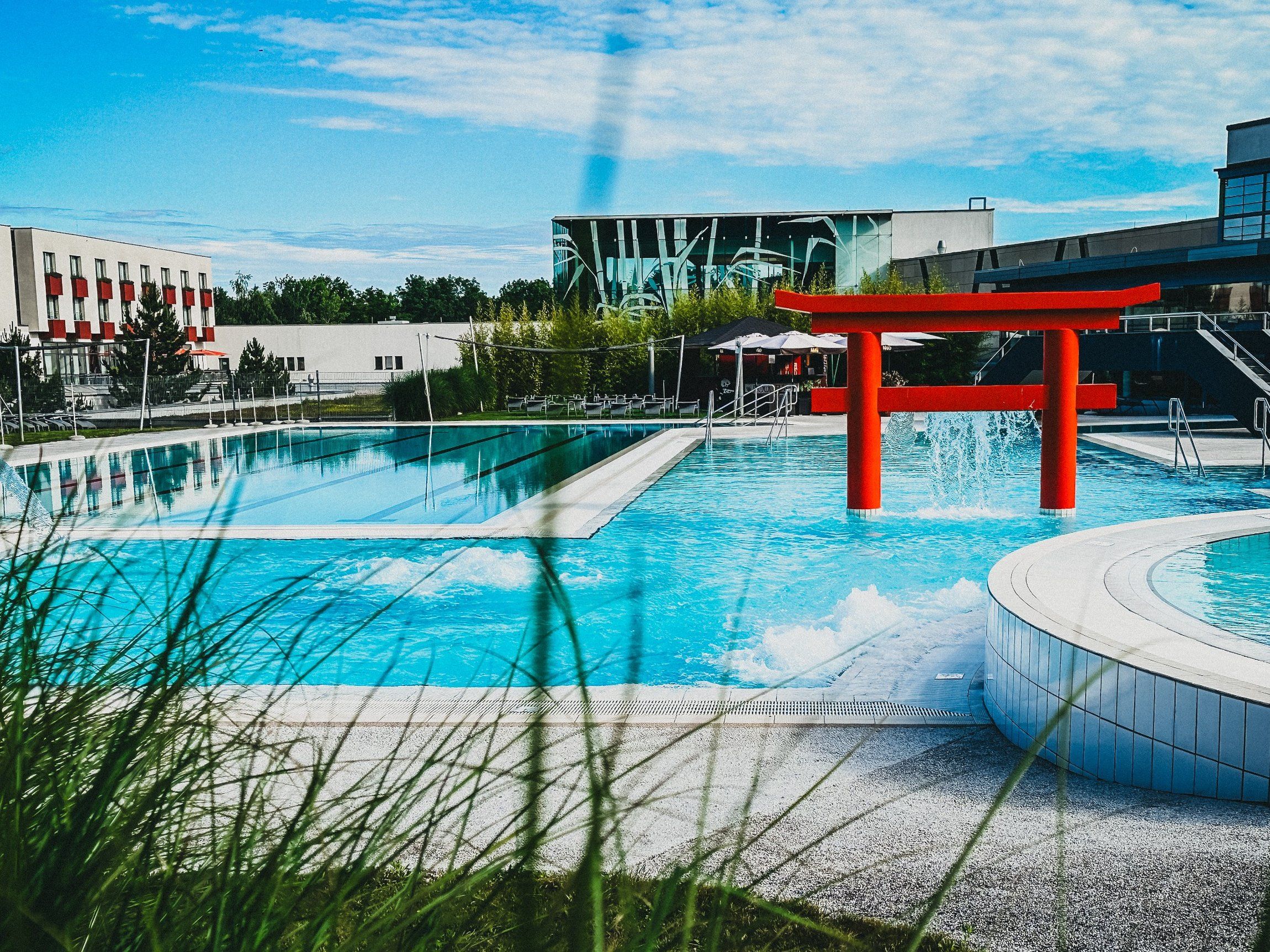 Außenansicht der Linsberg Asia Therme mit Pool und rotem Torii.