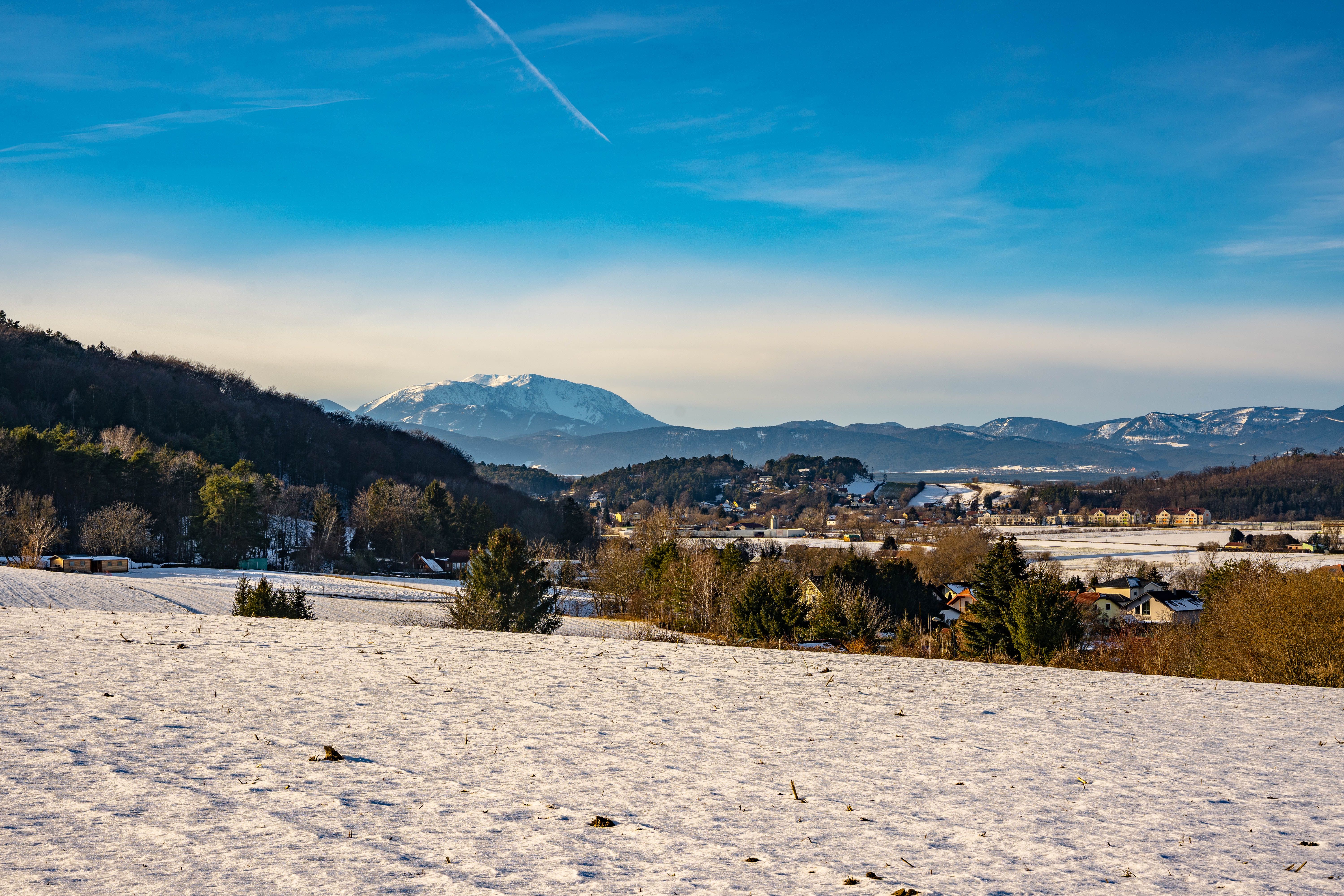 Winterlandschaft mit schneebedeckten Feldern und Schneeberg, im Hintergrund in Bad Erlach.