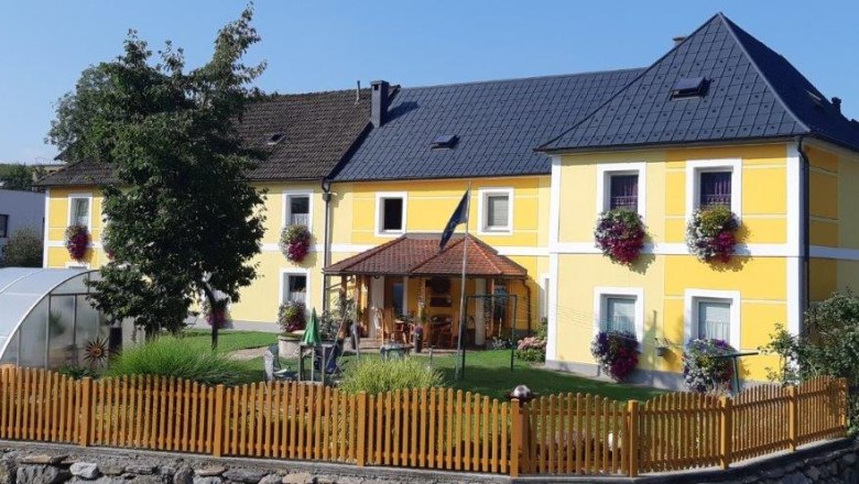 Gelbes Haus mit Garten und Holzzaun