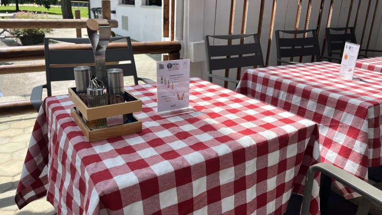 Gedeckter Tisch mit roter Tischdecke und Speiseempfehlung.