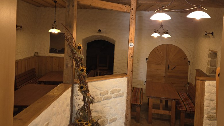 Gem&uuml;tlicher Innenraum eines rustikalen Gasthauses mit Holzm&ouml;beln und Dekorationen.