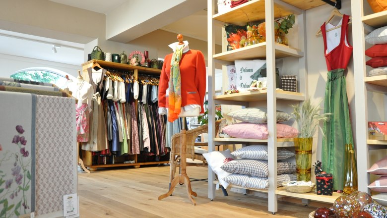 Innenansicht eines Geschäfts mit traditioneller Kleidung und Heimtextilien.