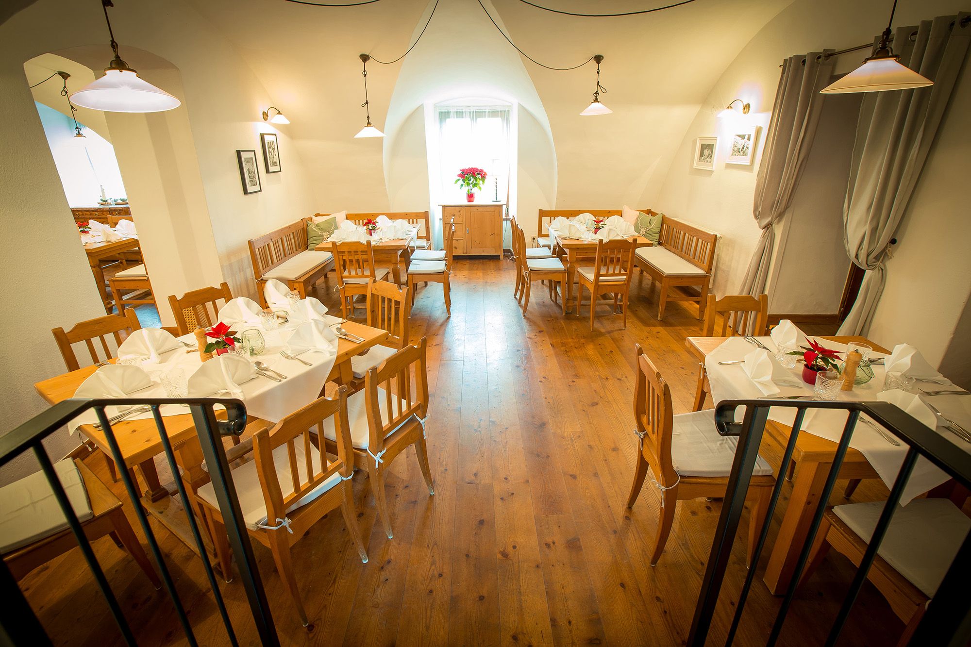 Gemütliches Restaurant mit Holzmöbeln und weiß gedeckten Tischen.