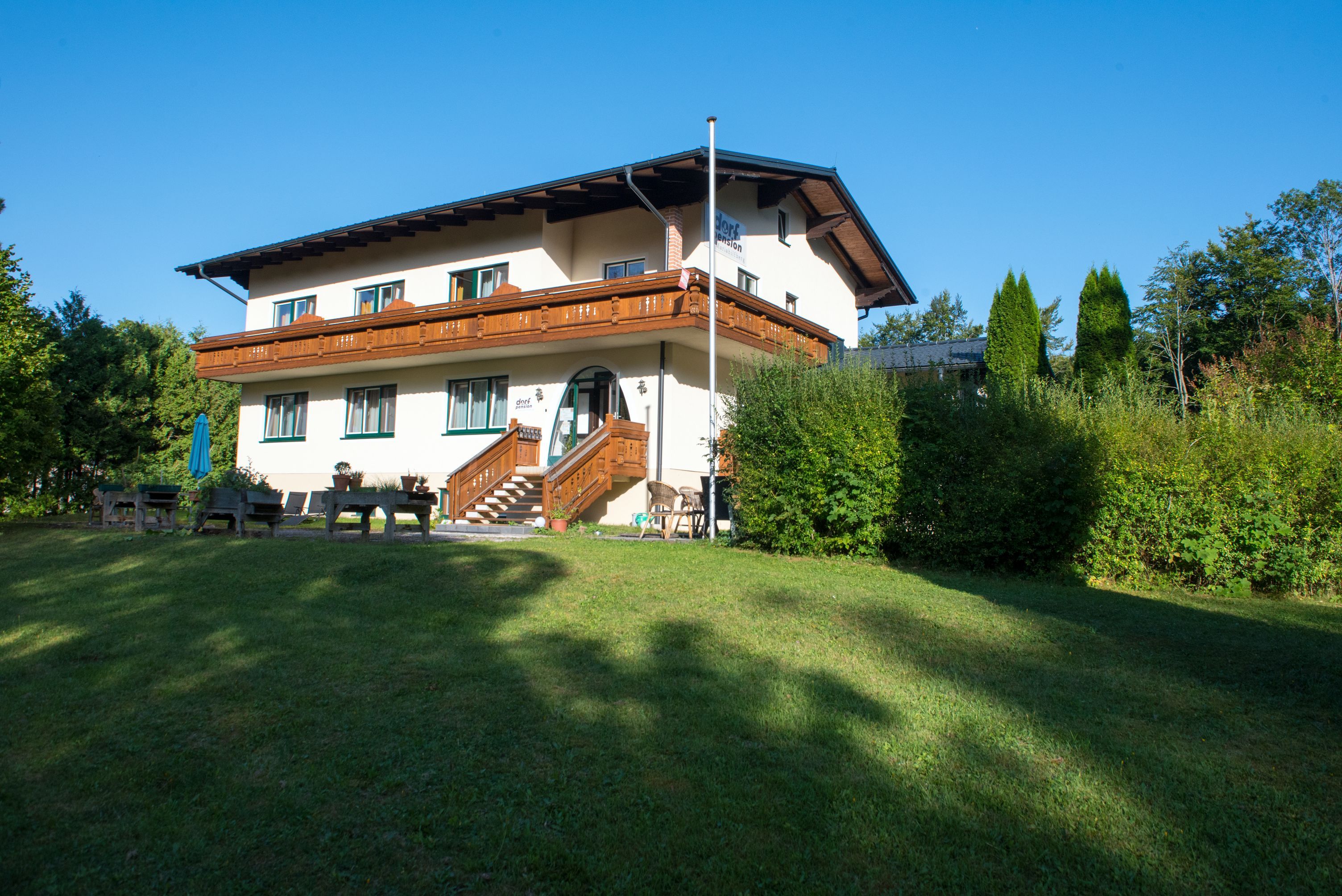 Zweistöckiges Haus mit Holzveranda und Garten.