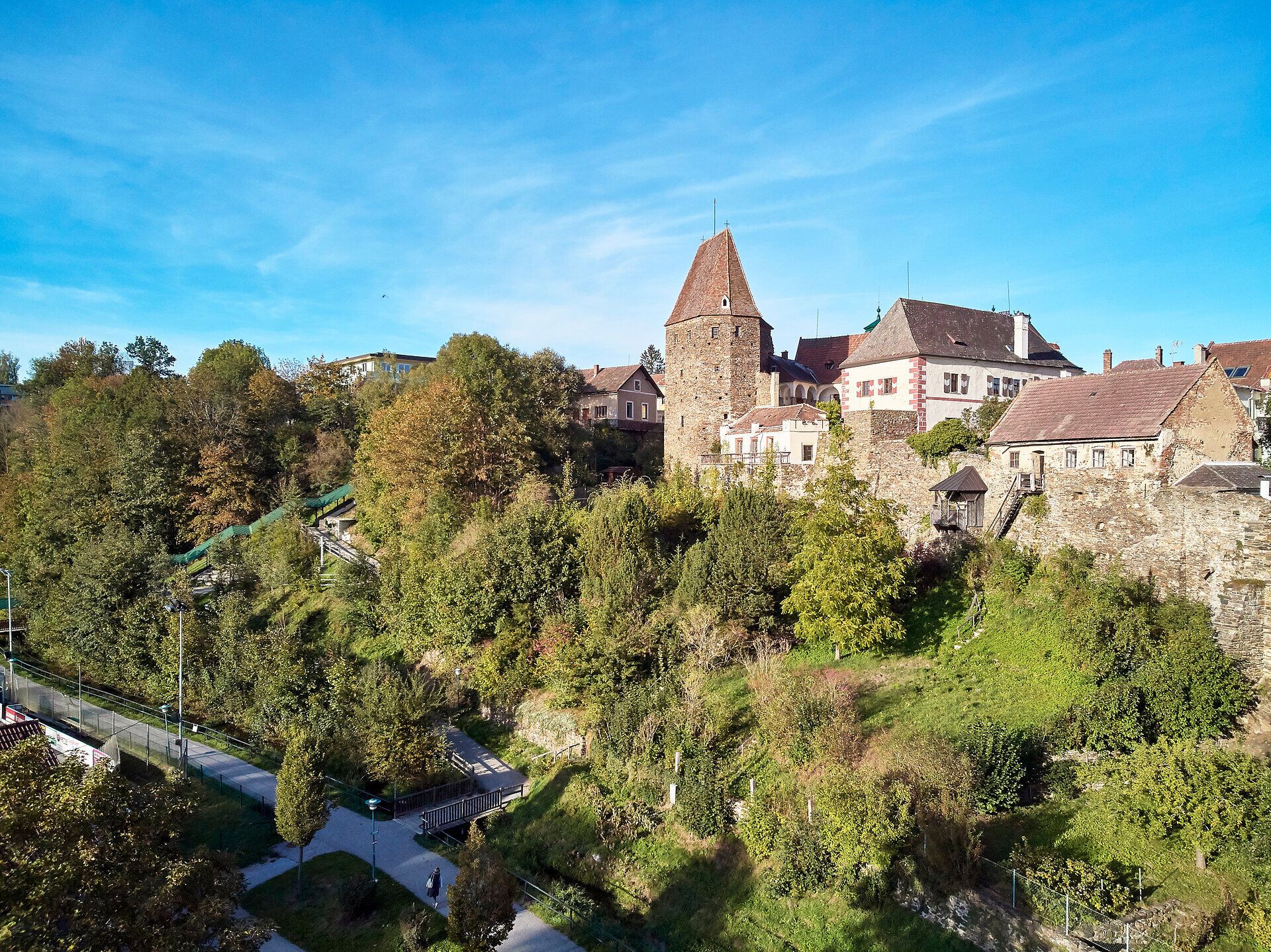 Luftaufnahme der Stadtmauer von Zwettl mit einem Turm und umliegenden Gebäuden.