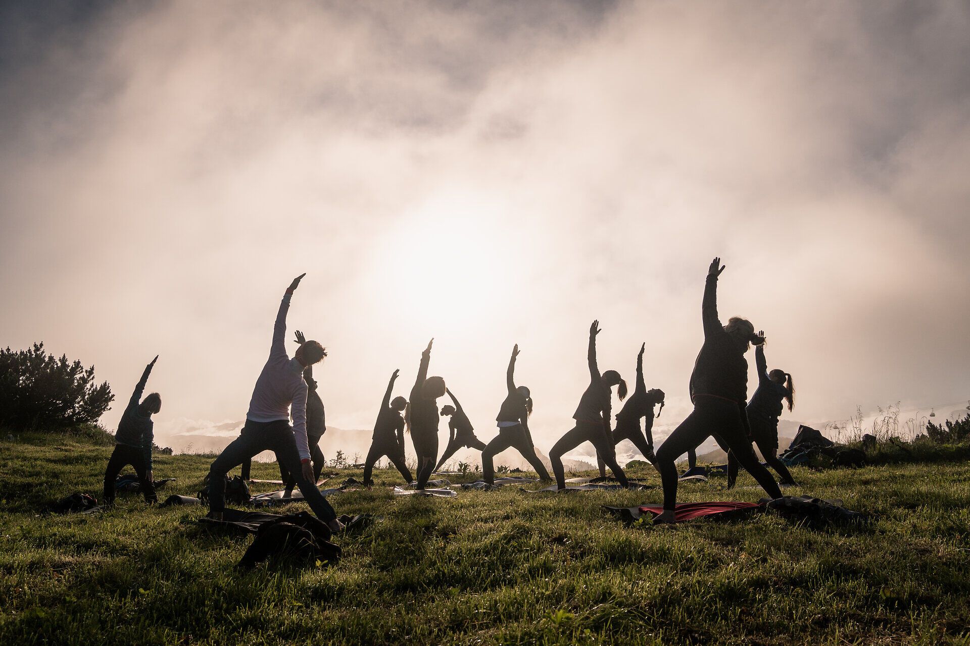In der sanften Morgenstimmung praktizieren die Teilnehmer Yoga inmitten der atemberaubenden Berglandschaft. Die harmonischen Bewegungen und die frische Luft schaffen eine Atmosphäre der Ruhe und des inneren Friedens. Umgeben von der majestätischen Natur wird jeder Atemzug zu einem Erlebnis der Verbundenheit mit der Umgebung.