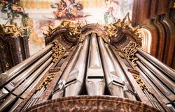 Die majestätischen Pfeifen des Orgelwerks erheben sich in den barocken Hallen und verleihen dem Raum eine ergreifende Akustik. Die kunstvollen Verzierungen und der Glanz des Metalls spiegeln die Pracht vergangener Zeiten wider und laden Besucher ein, in die musikalische Geschichte einzutauchen.