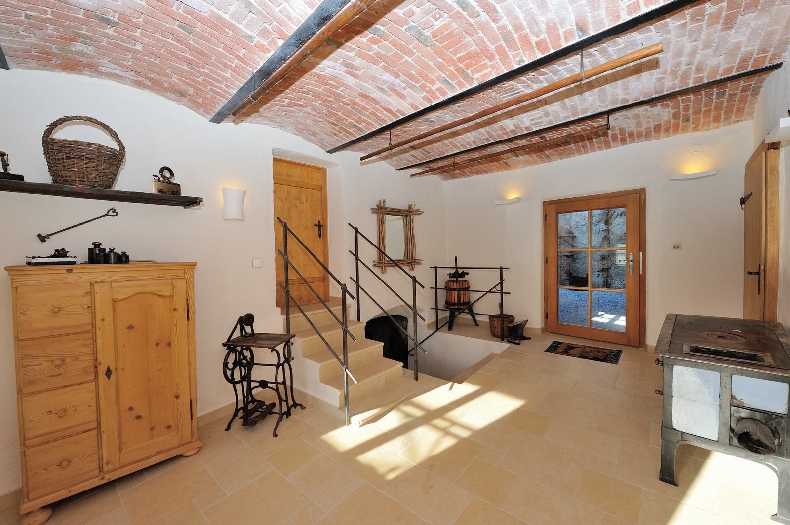 Innenraum mit Gewölbedecke, Holzmöbeln und antiken Gegenständen.