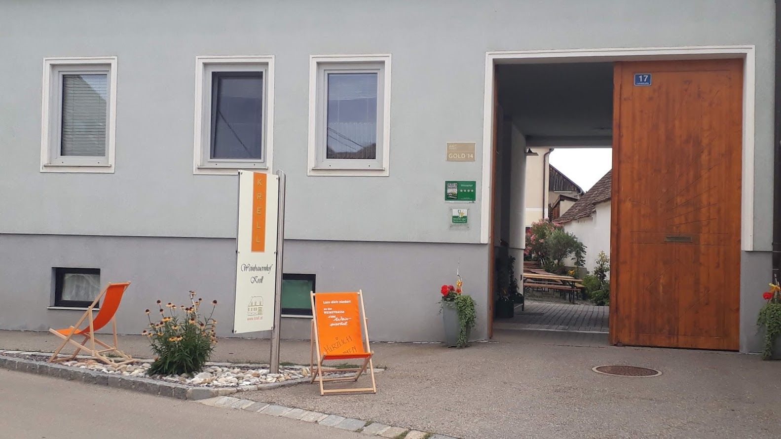 Eingang eines Weinguts mit Schild 'Krell', Liegestuhl und Pflanzen.