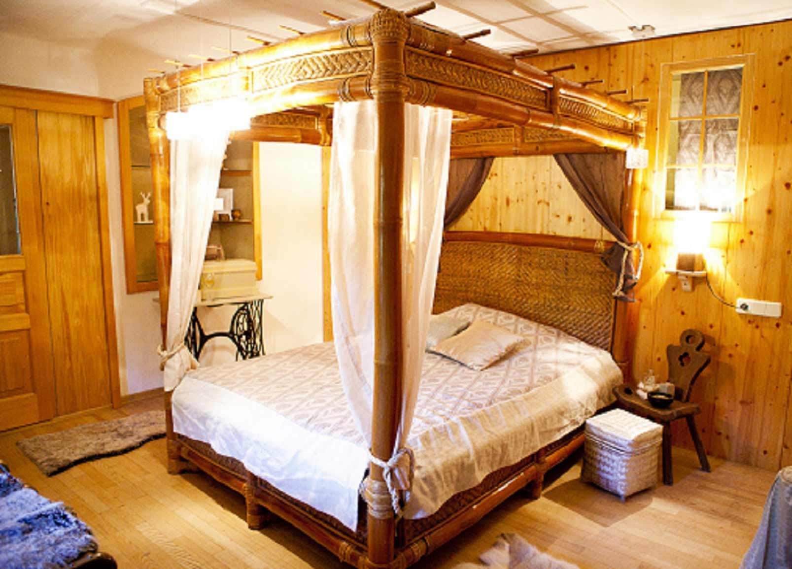 Gemütliches Schlafzimmer mit Himmelbett aus Holz und rustikaler Einrichtung.