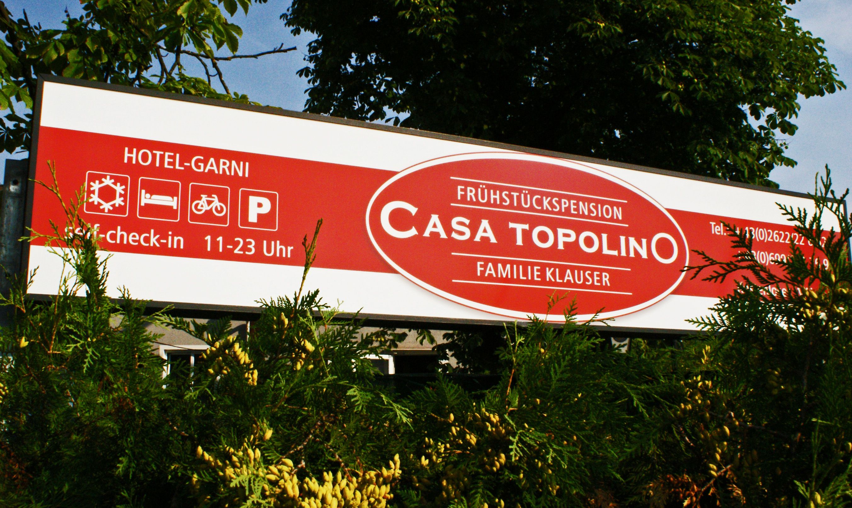Schild der Frühstückspension Casa Topolino mit Kontaktinformationen und Öffnungszeiten.