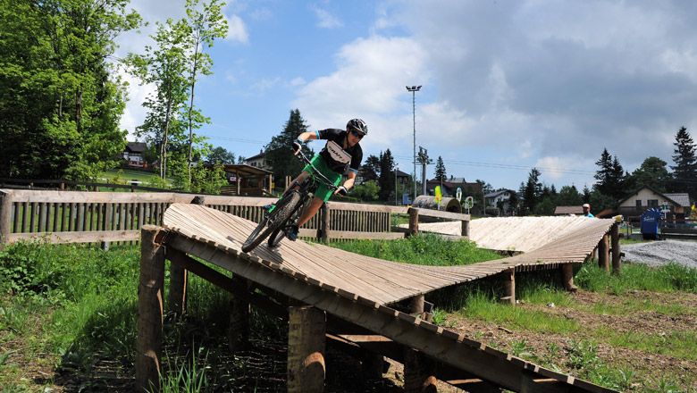 Kind fährt auf Holzrampe im Bikepark Semmering.
