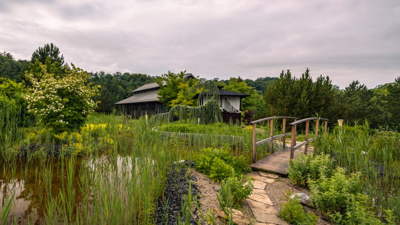 Asiatisch inspiriertes Geb&auml;ude mit Garten und Teich.