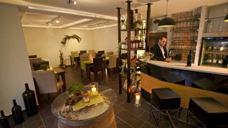 Ein stilvoller Verkostungsraum mit Bar, Tischen und Dekoration.