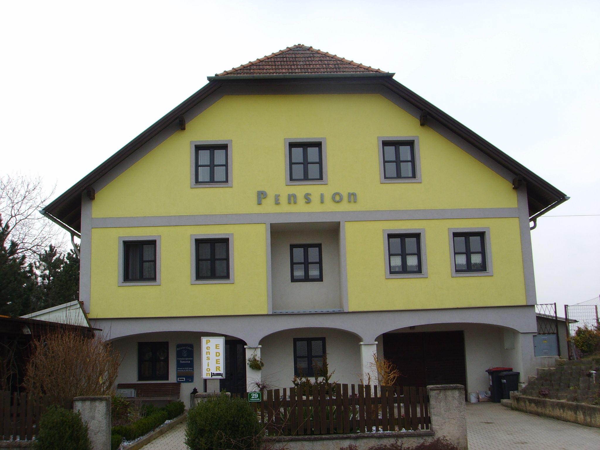Gelbes Gebäude mit der Aufschrift 'Pension'.