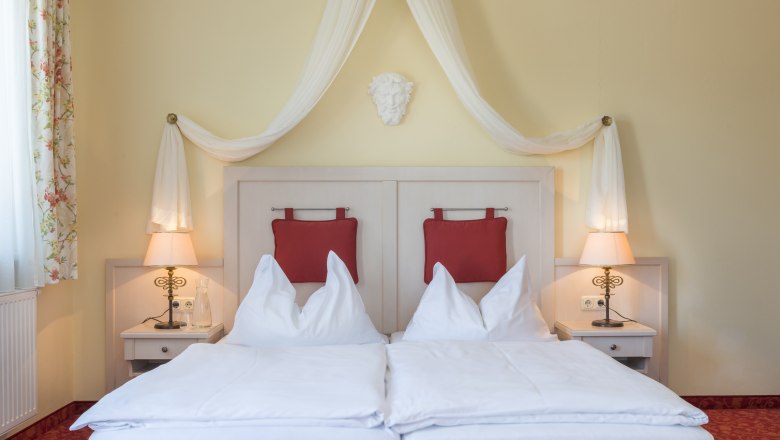 Zimmer Hotel Wachau, © Hotel Wachau Zimmeransicht mit Himmelbett und roten Polstern