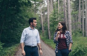 Zwei Personen spazieren durch den Föhrenwald