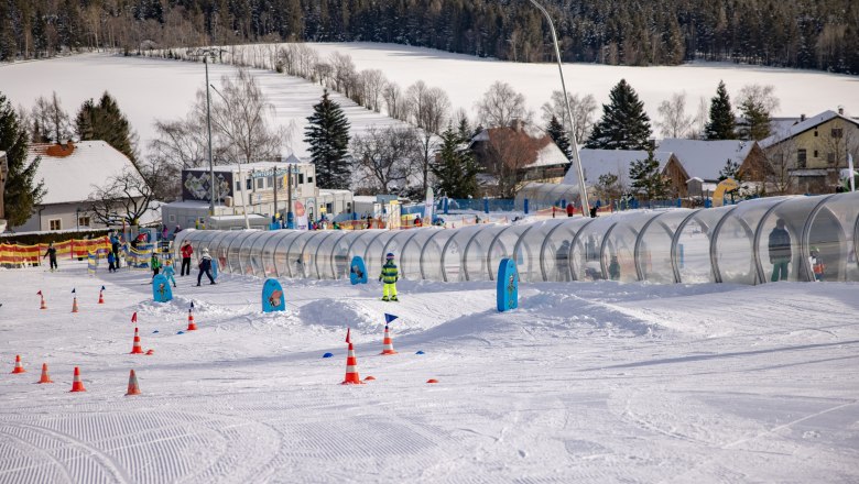 Skischule in St. Corona am Wechsel mit Kindern auf der Piste und F&ouml;rderband.