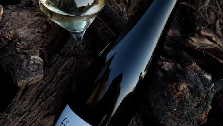 Weinflasche und Glas auf Holz.