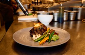 Wolfgang Puck Kitchen + Bar, Fleisch wird am Teller flambiert