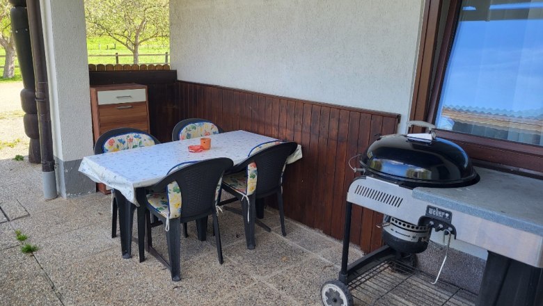 Terrasse mit Tisch, St&uuml;hlen und Grill.