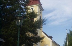 Au&szlig;enansicht der Pfarrkirche Sulz mit Turm und Uhr.