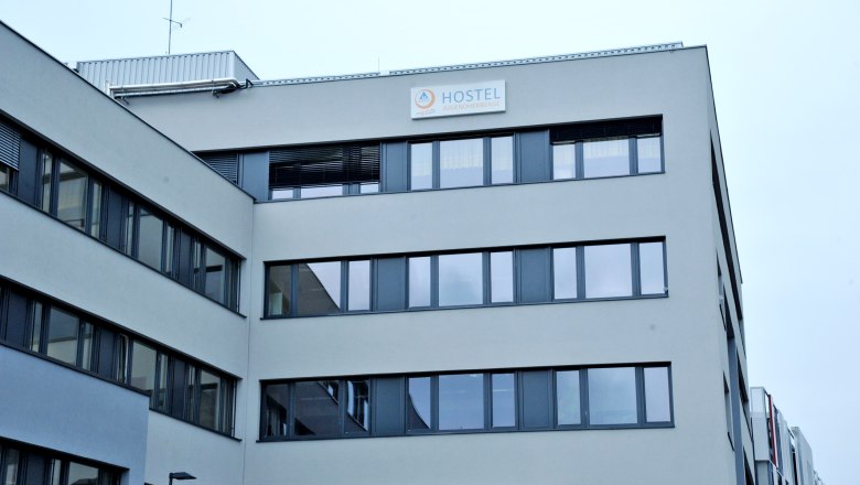 Modernes Geb&auml;ude mit Schild 'Hostel Jugendherberge'.