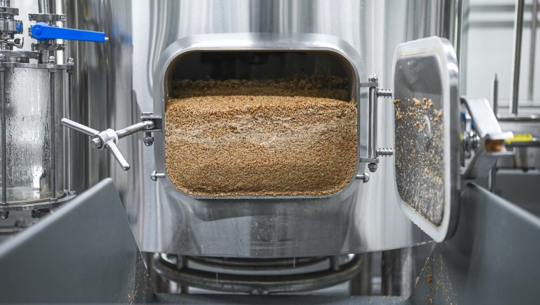 Geöffneter Braukessel mit Getreideresten in einer Brauerei.
