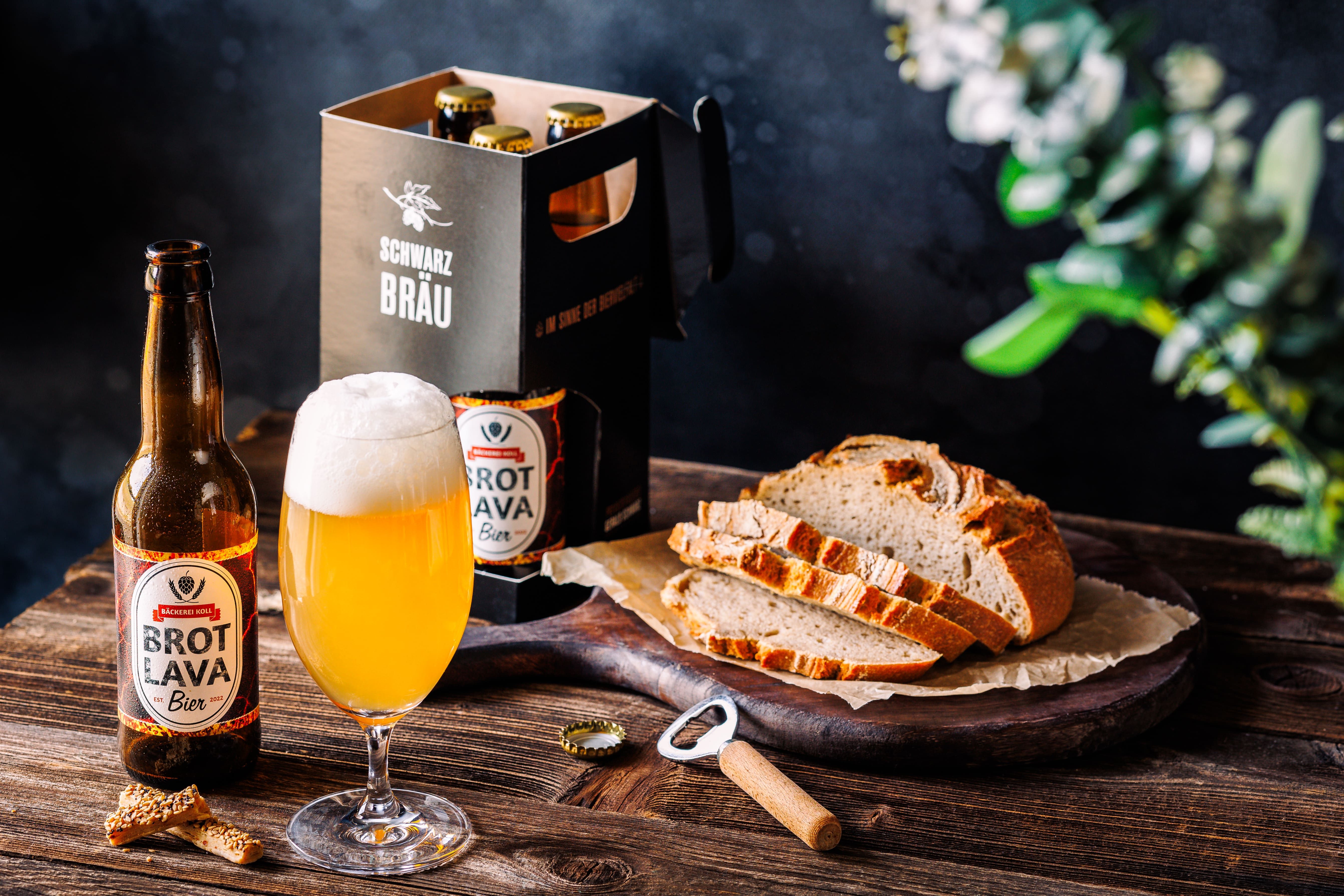 Bierflasche und Glas mit Brot auf Holztisch.