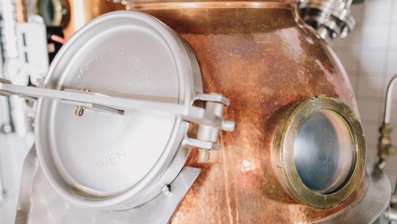 Nahaufnahme einer Kupferdestille mit Metallverschluss und Sichtfenster.