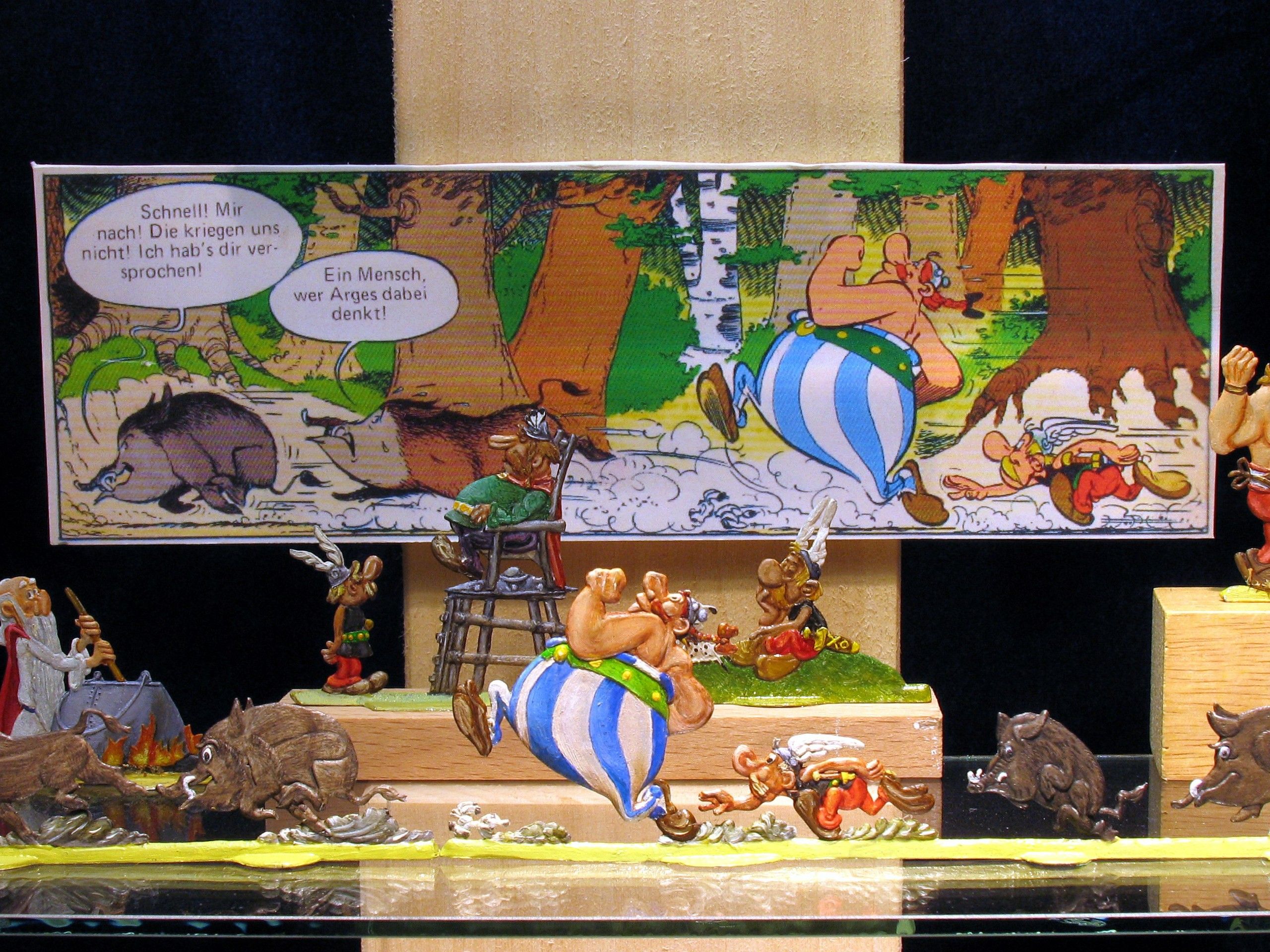 Zinnfiguren von Comic-Charakteren vor einem Comic-Hintergrund.