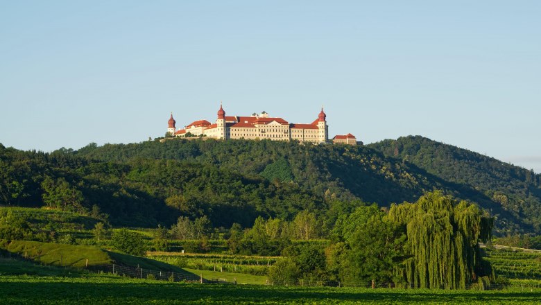 Benediktinerstift Göttweig auf einem Hügel mit grüner Landschaft im Vordergrund.