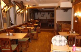 Innenansicht eines Restaurants mit Holzmöbeln und Dekorationen.