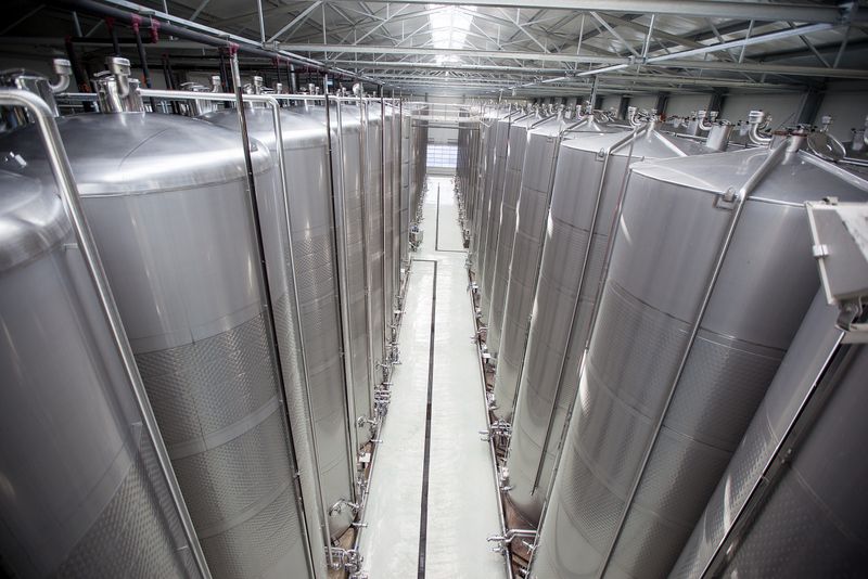 Große Edelstahltanks in einer modernen Weinproduktionshalle.
