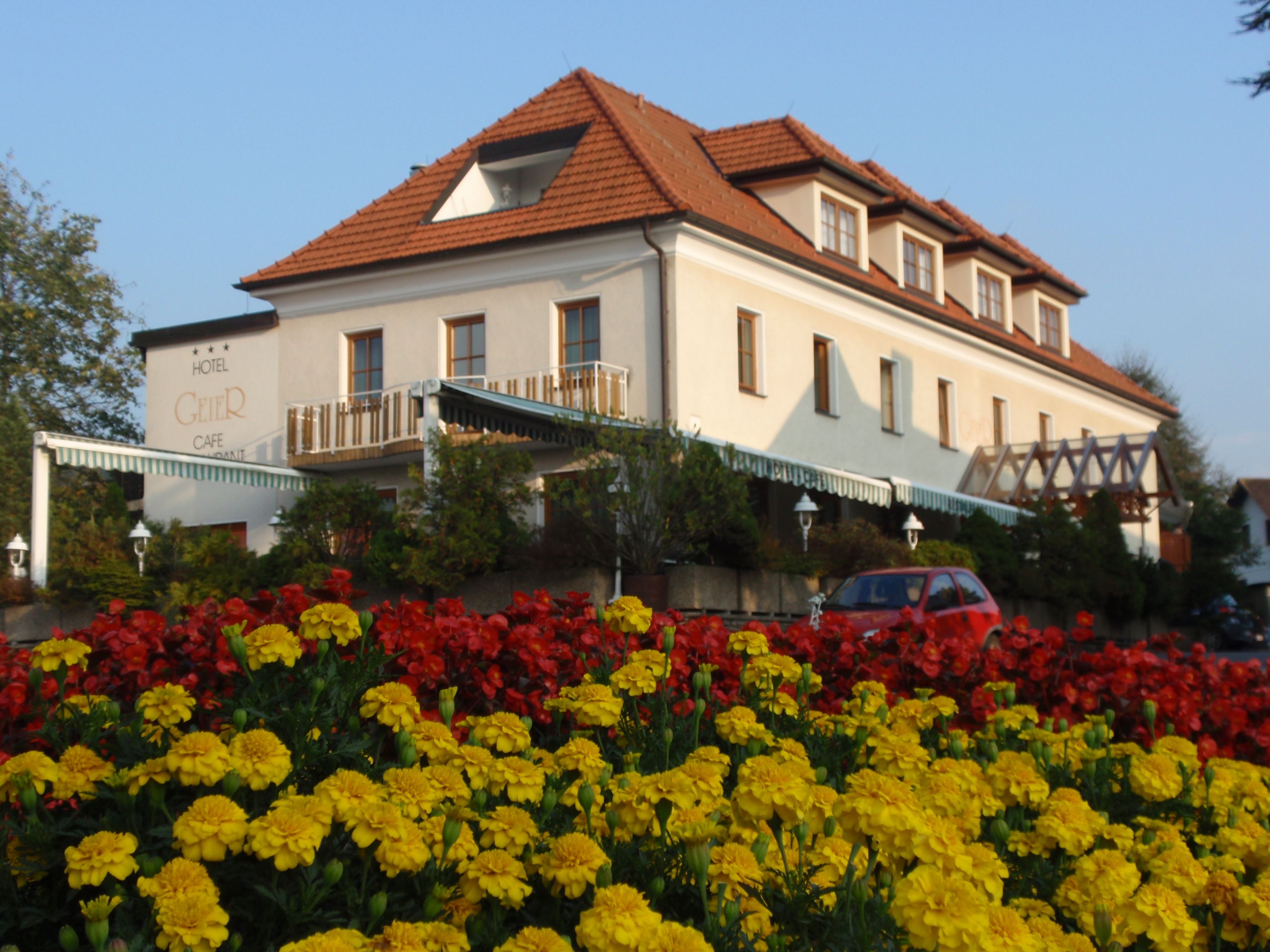 Hotel Geier in Bad Schönau mit Blumenbeet im Vordergrund.