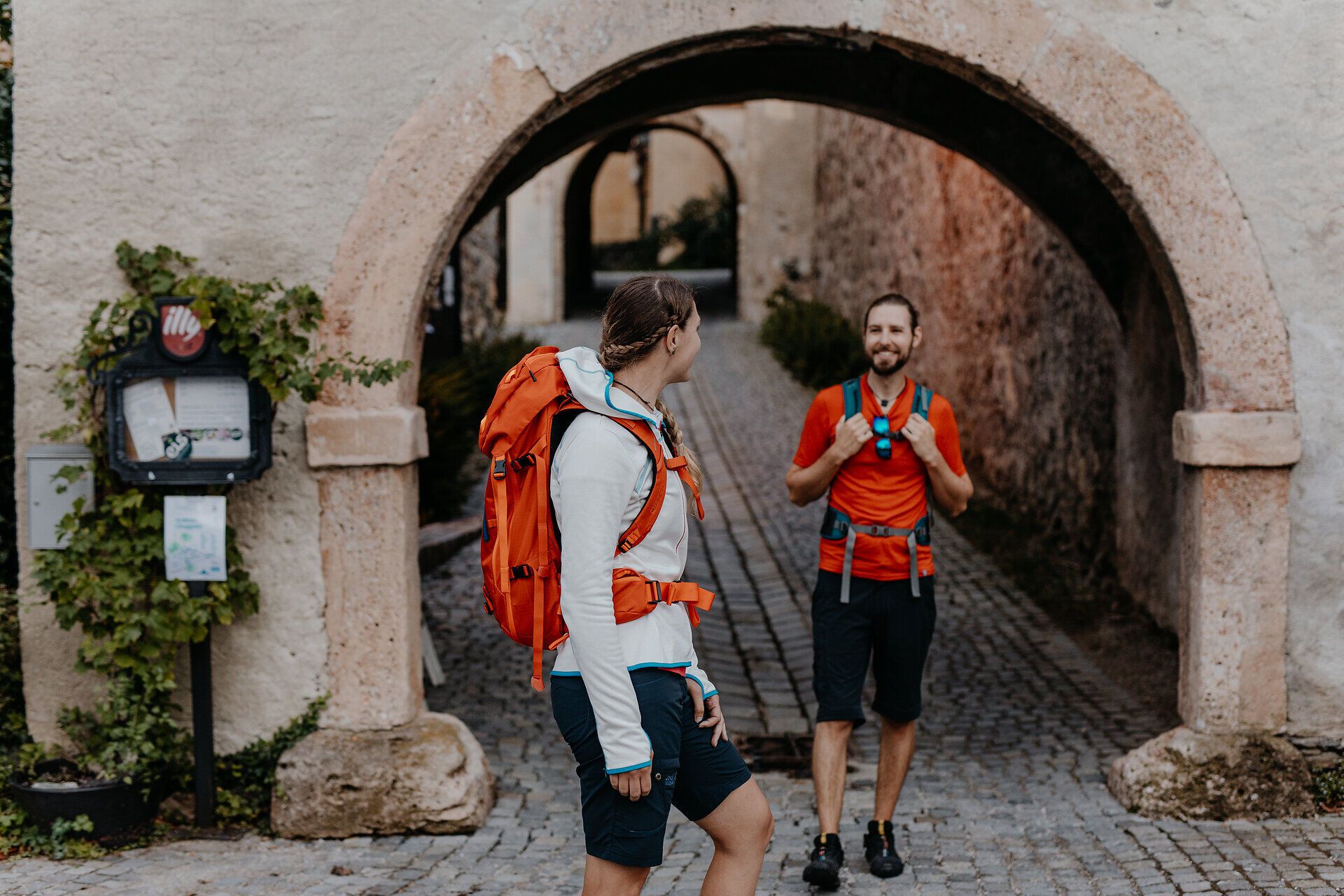 Zwei Wanderer stehen am Eingangstor zum Schloss Gloggnitz