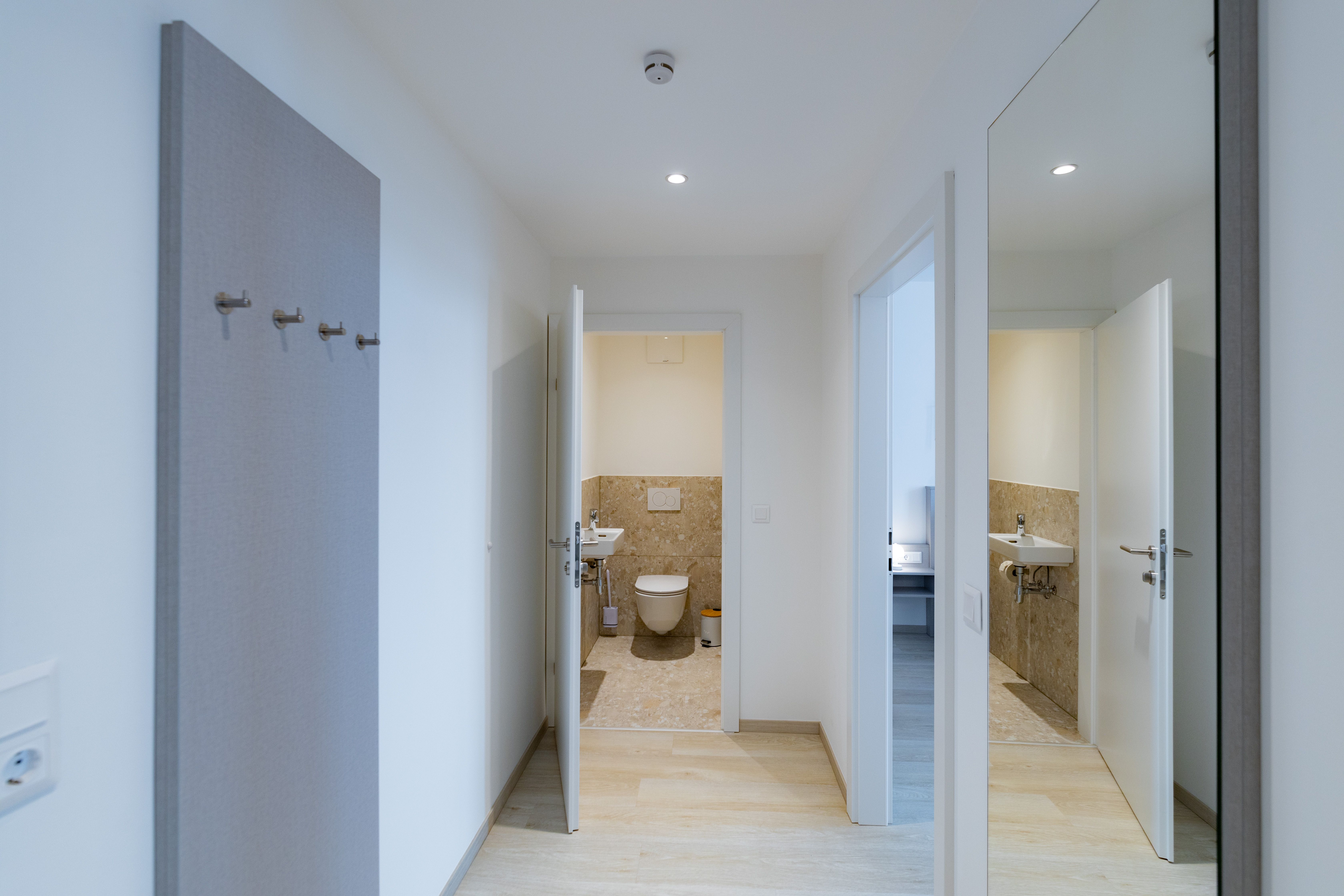 Flur mit Blick ins Badezimmer und Spiegel an der Wand.