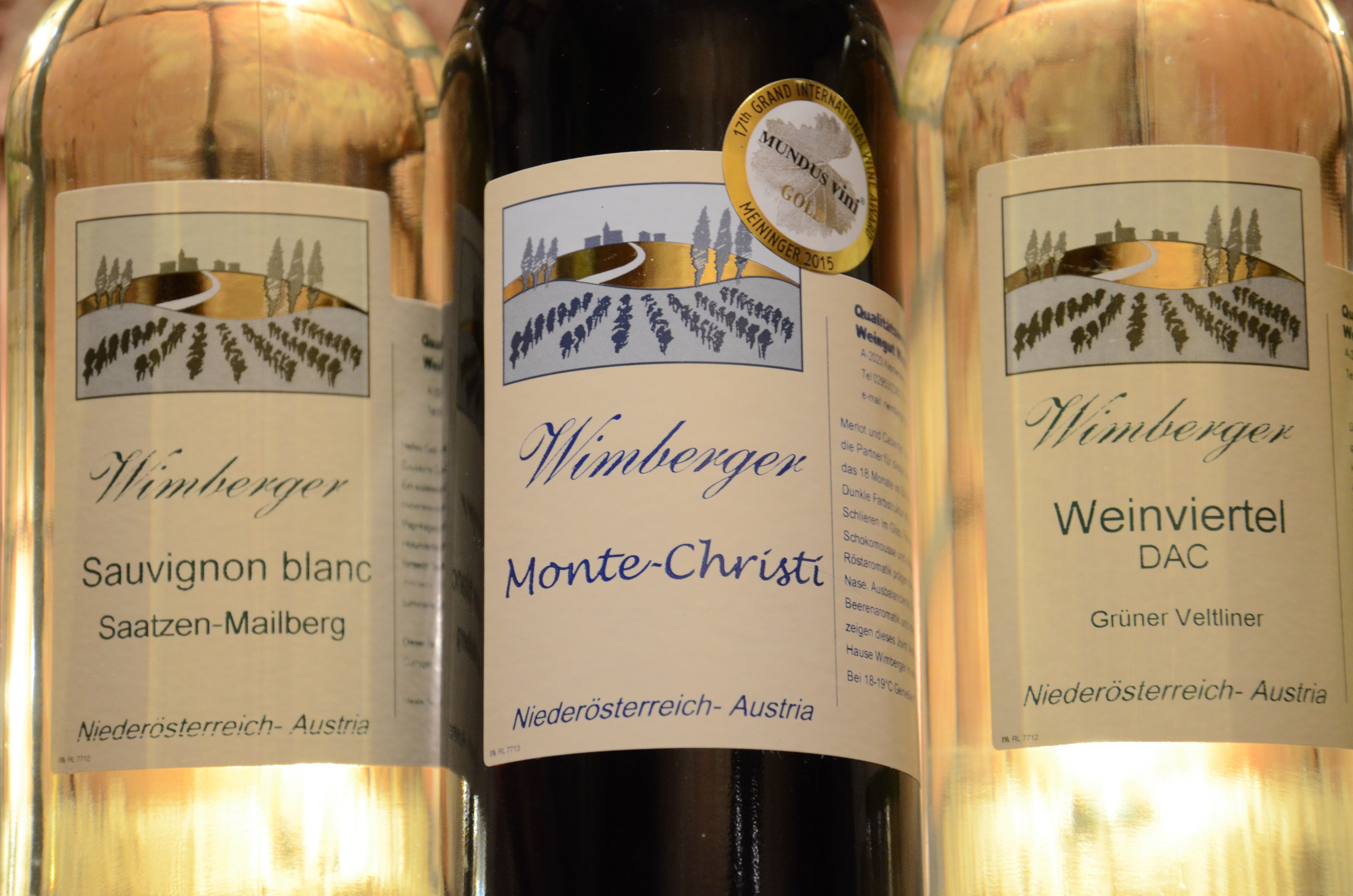 Drei Weinflaschen der Marke Wimberger mit Etiketten für Sauvignon Blanc, Monte-Christi und Weinviertel DAC.
